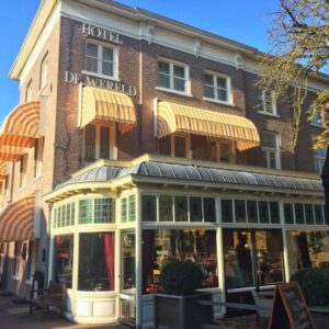 Hotel De Wereld met zonnige gevel en luifels.