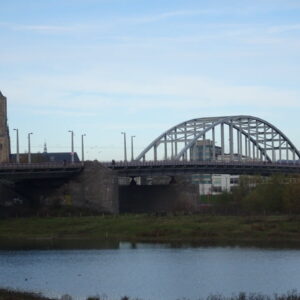 Brug over rivier met stadstoren op achtergrond.
