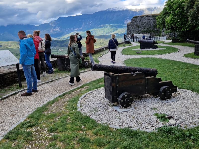 Bezoekers bekijken historische kanonnen in bergachtig landschap.