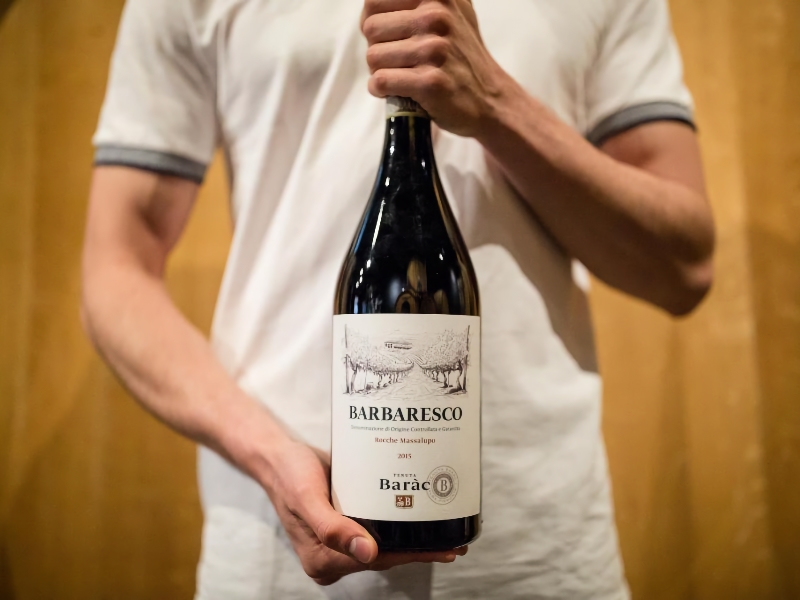 Persoon houdt Barbaresco wijnfles vast