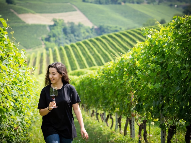 Vrouw geniet van wijn in een groene wijngaard