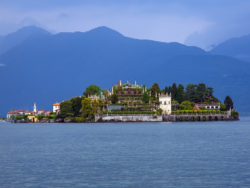 Eiland met bergen en paleis op meer.