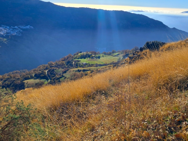 Heuvelachtig landschap met zonnestralen en valleizicht.