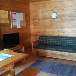 Knusse houten woonkamer met bank en tafel.