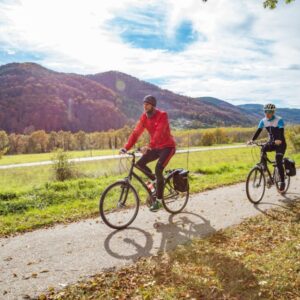 Twee fietsers op pad door natuurgebied in de herfst.