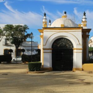 Historisch gebouw in zonnig park met blauwe lucht.
