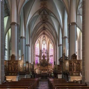 Interieur van een gotische kerk met gebrandschilderde ramen.