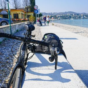 Fiets naast waterweg met wandelpad en bankje.