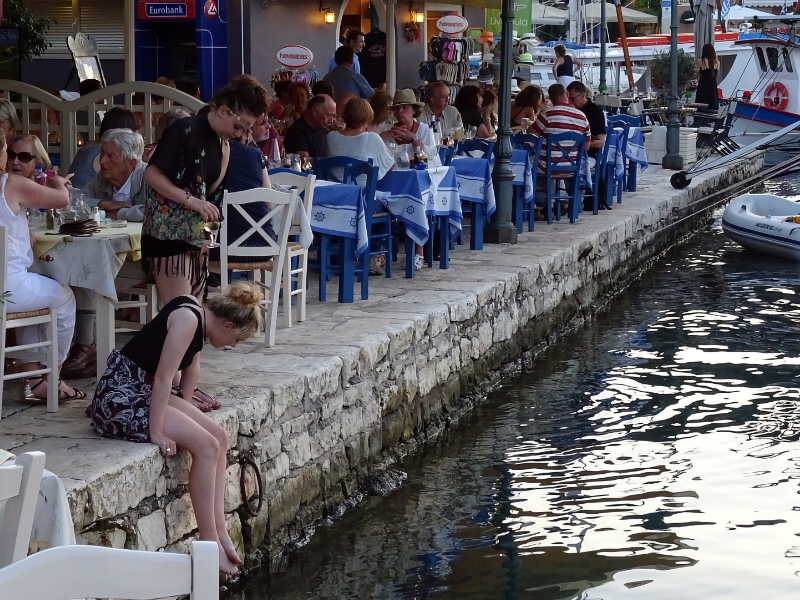 Restaurant aan het water met gasten op terras.