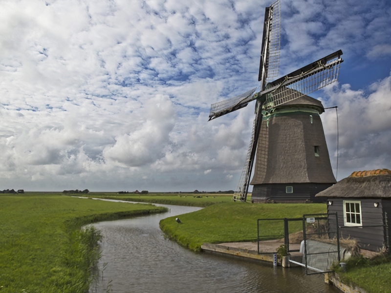 Traditionele molen bij Nederlandse sloot.