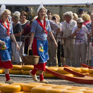 Traditionele kaasmarkt met vrouwen in klederdracht.