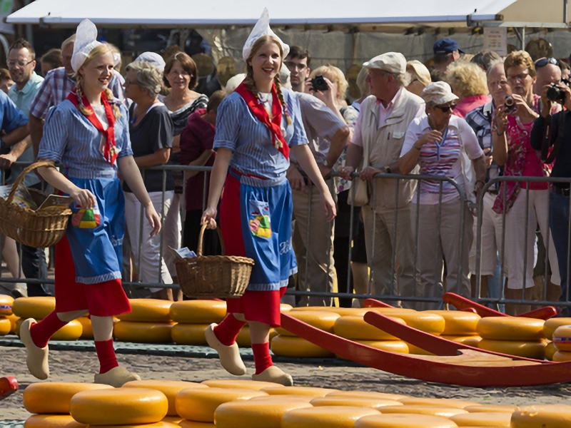 Traditionele kaasmarkt met vrouwen in klederdracht.