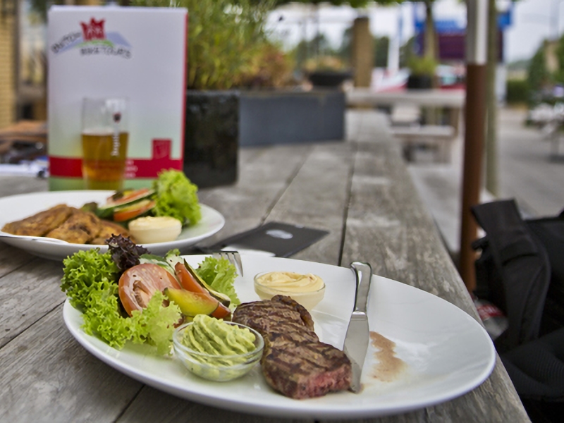 Twee borden met steak en groentesalade op tafel.