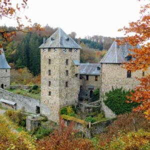 Middeleeuws kasteel omringd door herfstkleuren en natuur.