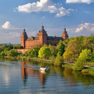 Kasteel aan rivier met boot en bomen