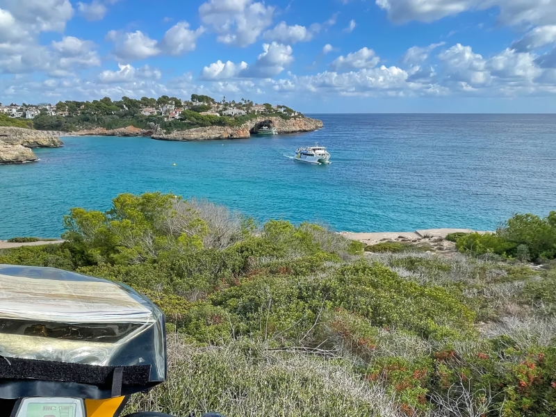 Kustlijn met blauwe zee en boot op water.
