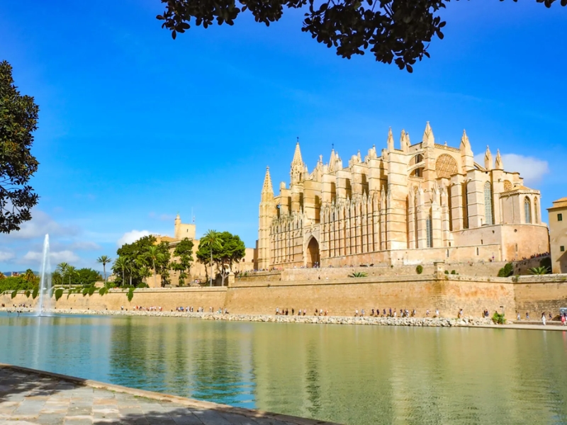 Grote kathedraal aan het water onder blauwe hemel.
