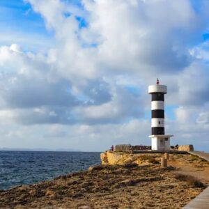 Vuurtoren aan de kust bij bewolkte hemel