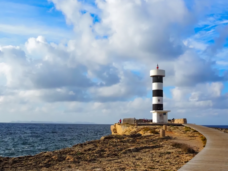 Vuurtoren aan de kust bij bewolkte hemel