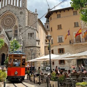 Rode tram in historische stad met kerk.