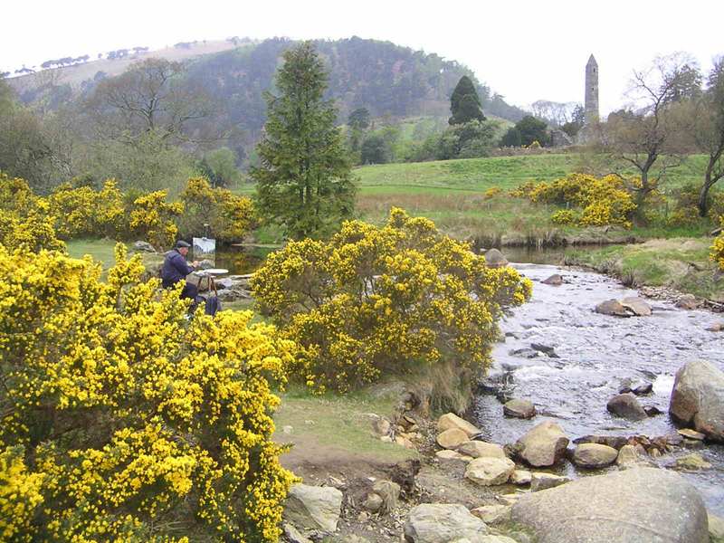 Schilder schildert landschap met rivier en toren