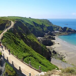 Wandelroute langs groene klifkust met uitzicht op zee.