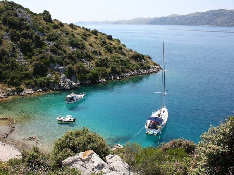 Zeilboten in heldere baai met turquoise water