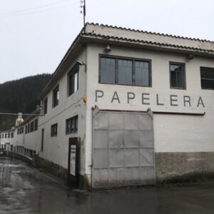 Oude papierfabriek met bord 'Papelería' op gevel.