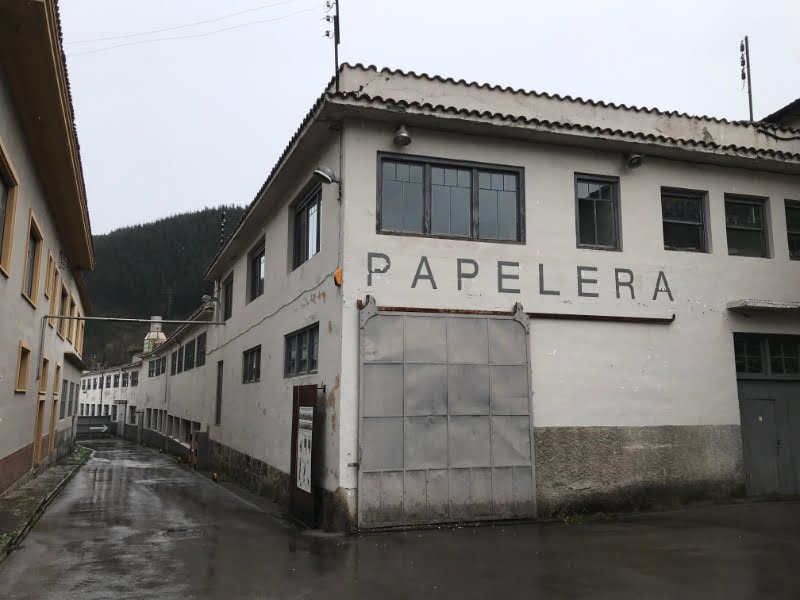 Oude papierfabriek met bord 'Papelería' op gevel.