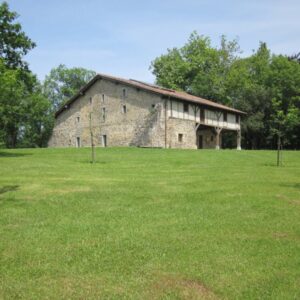Stenen gebouw op groene heuvel met bomen