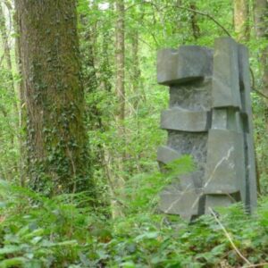 Betonnen sculptuur in groen boslandschap