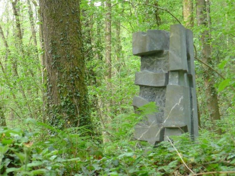 Betonnen sculptuur in groen boslandschap