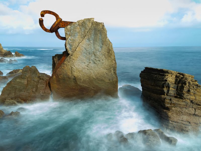 Rotsen met kunstwerk aan zee tijdens eb.