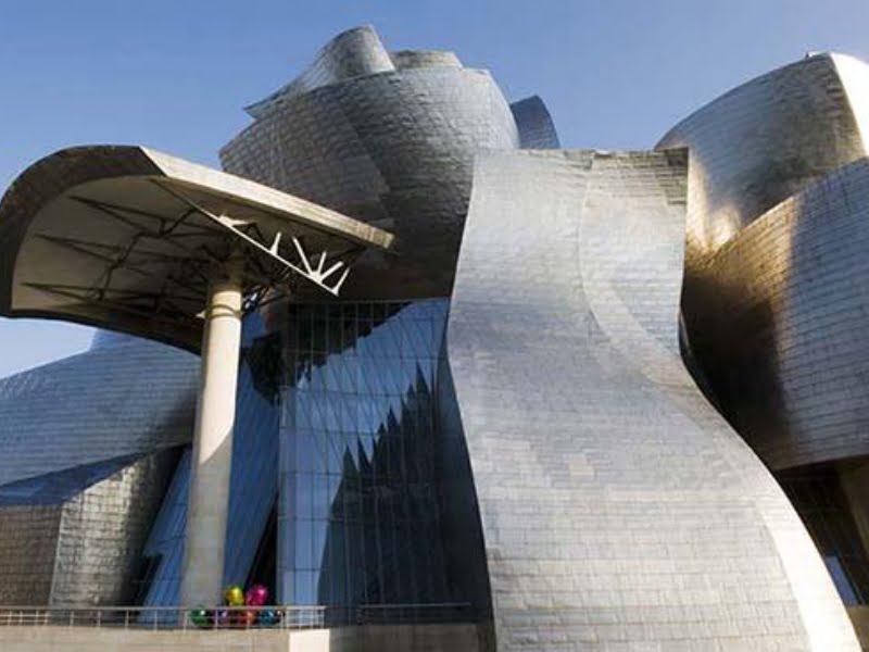 Moderne architectuur met metalen gevels in zonlicht.