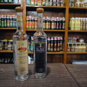 Twee flessen mezcal op houten aanrecht.