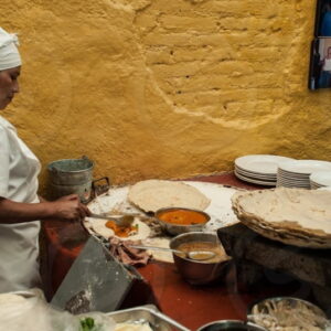 Vrouw maakt traditionele tortilla's in keuken.