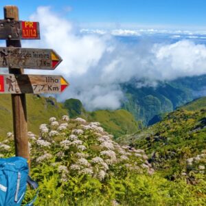 Wandelpad bord met berglandschap en wolken.