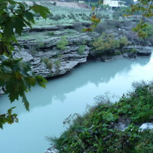 Rustige rivier omgeven door groene natuur en rotsen.