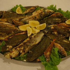 Geroosterde vis met citroen en sla op schaal.