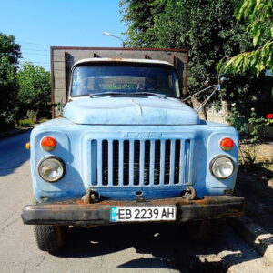 Oude blauwe vrachtwagen geparkeerd langs de straat