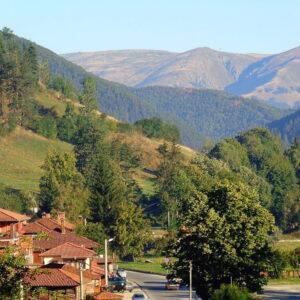 Rustiek dorp in groene heuvelachtige omgeving met bergen