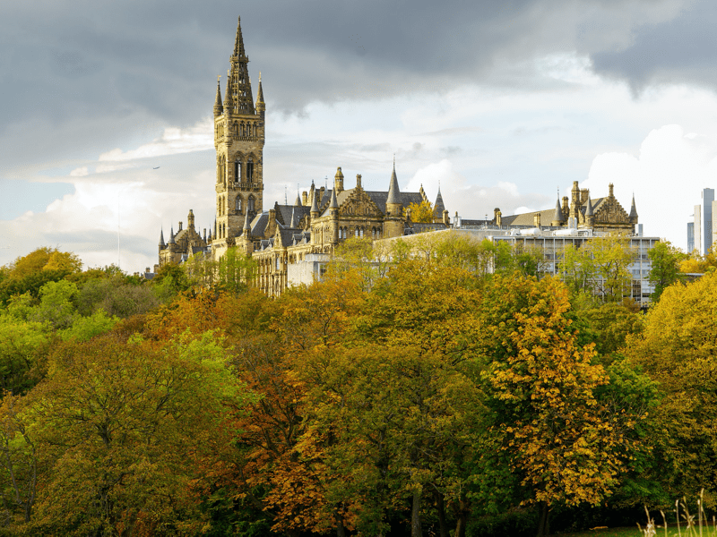 Hogeschoolcampus met torens en herfstige bomen
