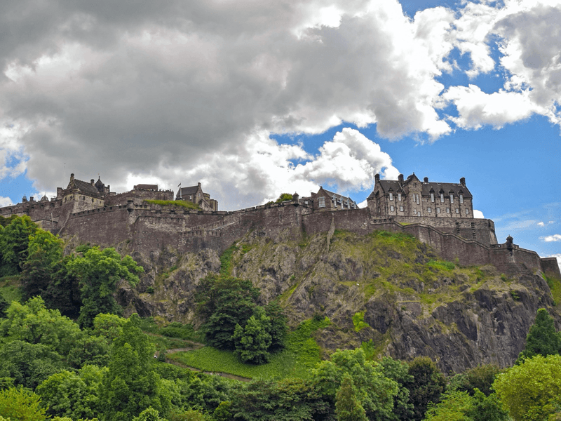 Kasteel op heuvel met wolkenhemel