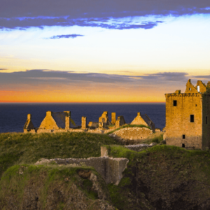 Middeleeuws kasteelruïne bij zonsondergang aan de kust.