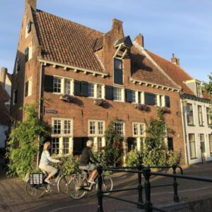 Fietsers voor historisch Nederlands bakstenen huis.