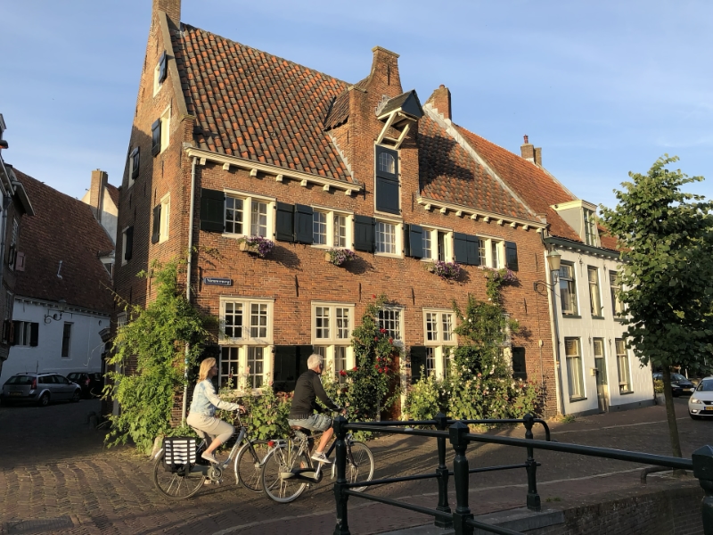 Fietsers voor historisch Nederlands bakstenen huis.