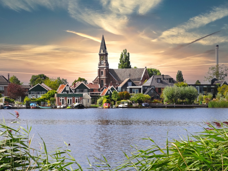 Idyllisch dorp aan de rivier bij zonsondergang.