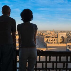 Twee personen kijken uit over historische stad.