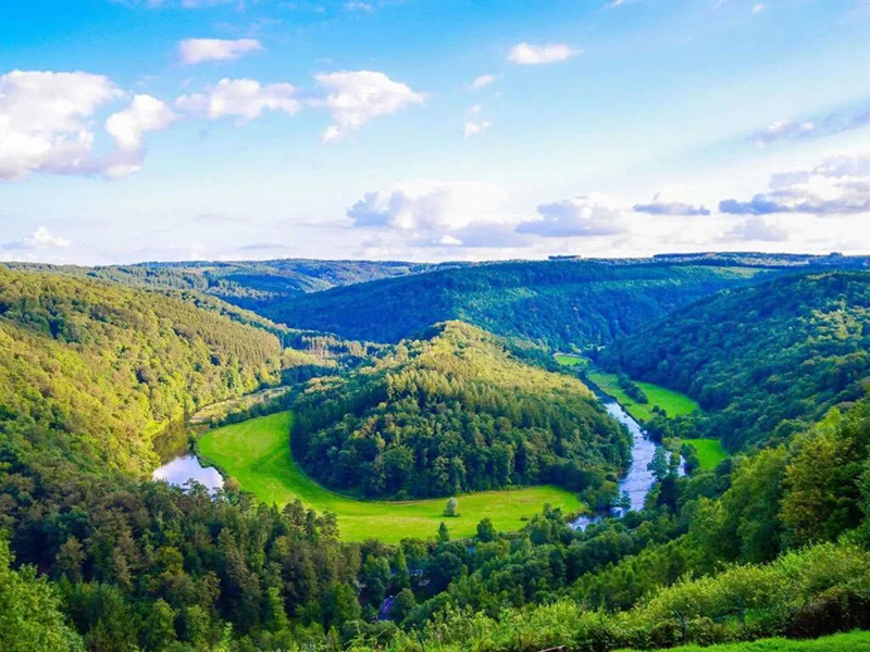Landschap met rivier en groene bossen in dal.