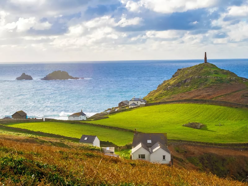 Groen landschap met zee en huizen op heuvels